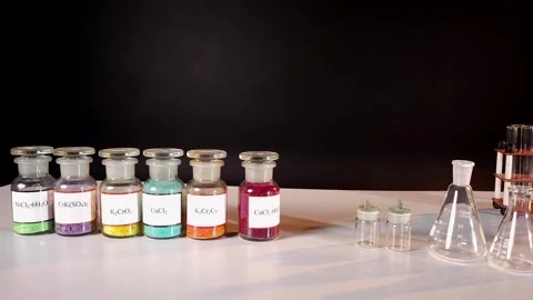 Six glass jars with multi-colored chemical compounds in powder form Stock Footage 311934016