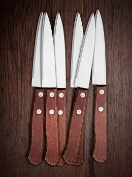Six knifes on rustic kitchen table Stock Photos