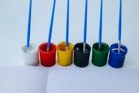 Six open paint pots in white, red, yellow, black, green. Stock Photos