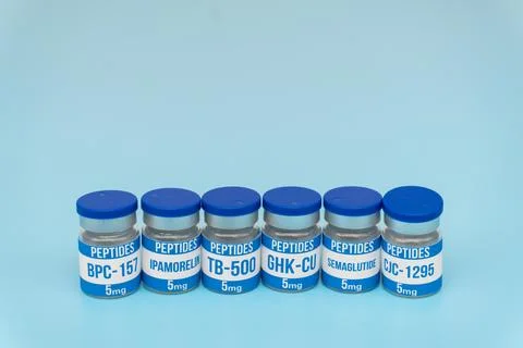 Six Peptide Vials with Different Labels on Blue Background, Studio Shot Stock Photos