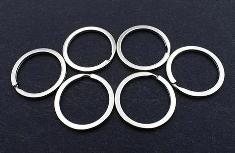 Six shiny silver metal split rings, essential components for crafting. Stock Photos