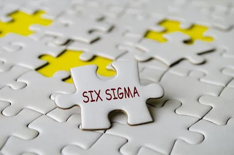 Six Sigma text on jigsaw puzzle. A methodology and set of tools used to imp.. Stock Photos