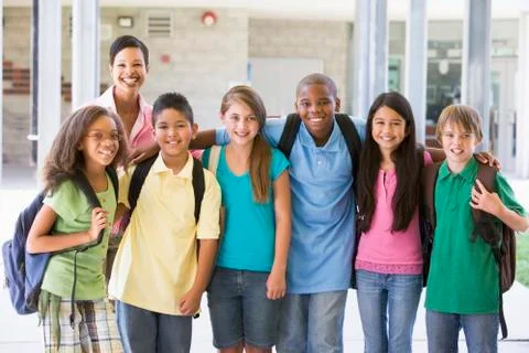 Six students standing outside school with teacher Stock Photos