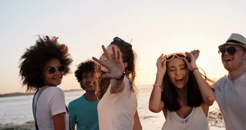Six teen multiethnic friends having fun near lake, dancing, looking at camera Stock Footage