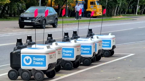 Six Wheeled Autonomous Courier Robots for Delivery Parked Beside City Road Stock Footage 345638664