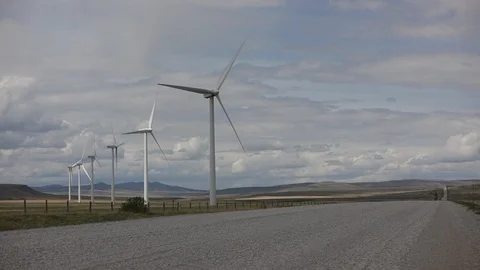 Six wind turbines in a field next to an urban road in Alberta Stock Footage 90856480