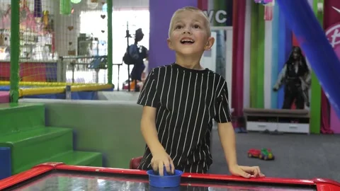 A six-year-old boy plays air hockey on the playground. Stock Footage 280152001