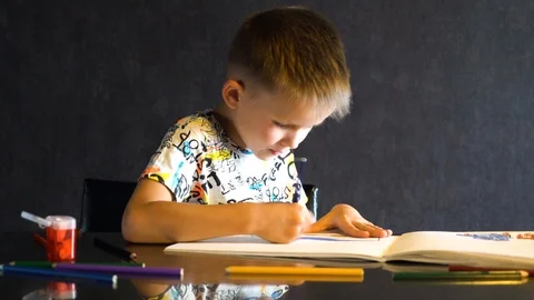 A six-year-old child draws with colored pencils. Stock Footage 109557085