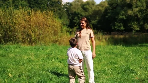 Six years old boy and his mom twirl together and laughing. Heartwarming Stock Footage 323082453