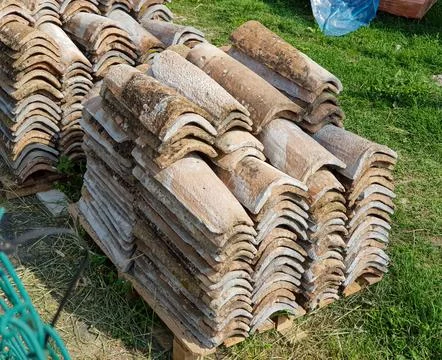A sizable stack of roof tiles is positioned atop a sturdy wooden pallet Stock Photos