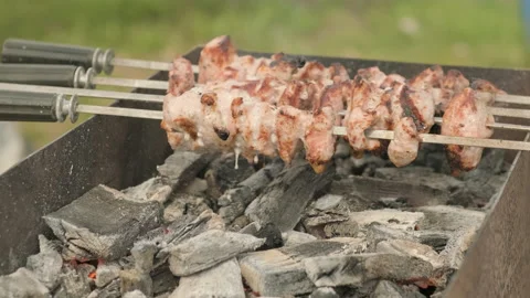 Sizzles and drips fat while marinated shashlik preparing on a barbecue grill Stock Footage 197593897