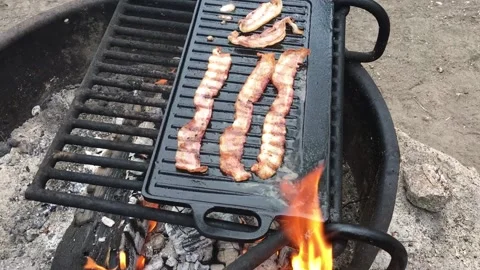 Sizzling Bacon on a campfire Stock Footage 168955857