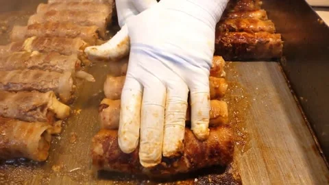 Sizzling Bacon-Wrapped Pork Belly and Kimchi Rolls on a Flat Top Griddle 動画素材 343588080