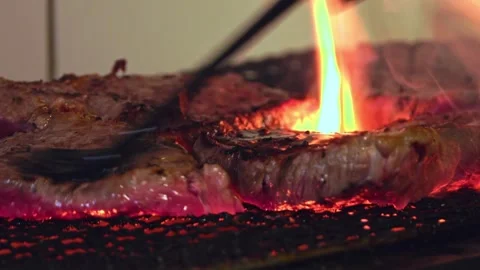 Sizzling Beef Perfection: Close-Up of a Juicy Steak Grilling to Flavorful Stock Footage 288691925