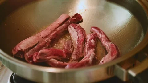 Sizzling Beef Strips Stir Frying in Stainless Steel Pan During Cooking Stock Footage 340954618