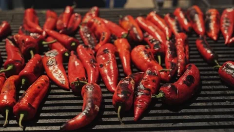 Sizzling charred red peppers cooking on hot plate BBQ Stock Footage 193368729