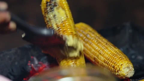 Sizzling Corn on the Cob Being Brushed with Savory Sauce Stock Footage 332161413