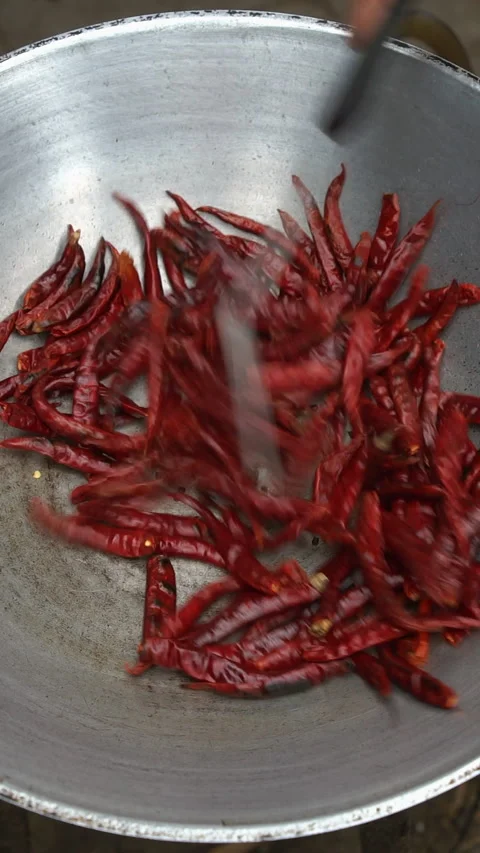 Sizzling dried red chili pepper roasting in metal wok with spatula creates .. Stock Footage 341273287