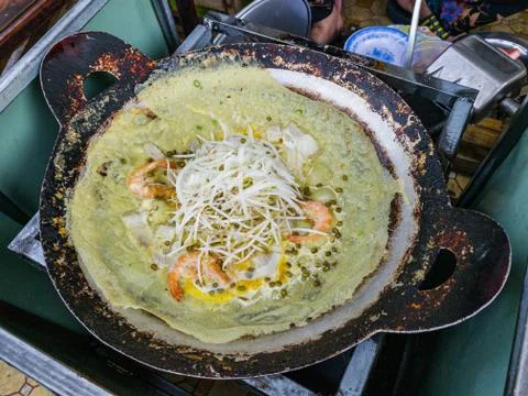 Sizzling fried pancake on rustic pan at Vietnamese street market Stock Photos