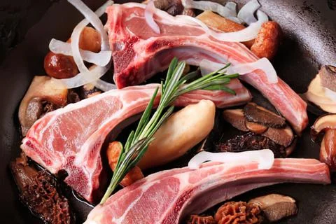 Sizzling lamb chops with vegetables and herbs Stock Photos