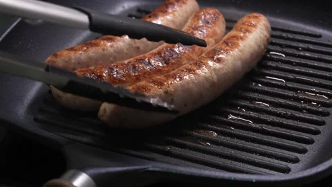 Sizzling Sausages cook on a Griddle. Stock Footage 253903812