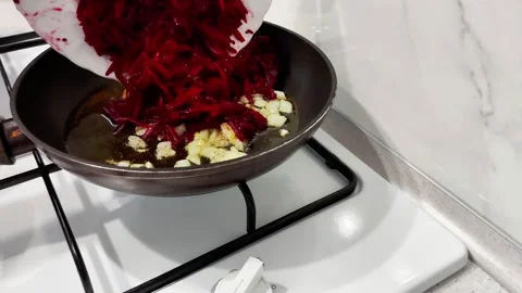 Sizzling Start: Beets and Garlic Hit the Pan on Gas Flame Stock-Footage 321049178