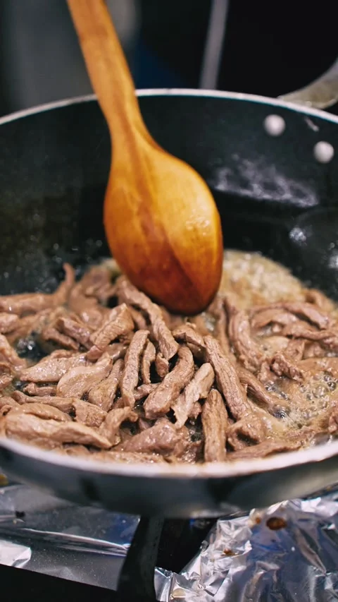 Sizzling Strips of Beef Meat Cooking in Hot Wok Pan Vertical Video Stock Footage 341013944