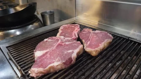 Sizzling T-Bone Steaks Grilling on a Hot Barbecue 스톡 동영상 332815132