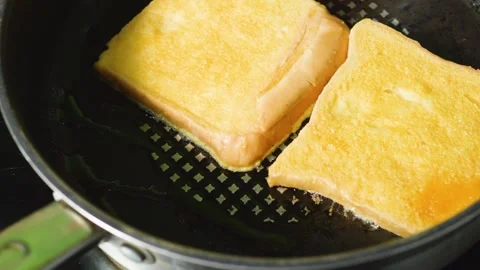 Sizzling white bread slices browning in butter on griddle pan, developing crisp Stock Footage 311989080