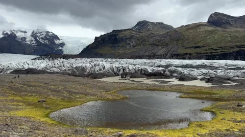 Skaftafellsjokull outlet glacier flowing down the valley with a proglacial lake  Stock Footage 331563742