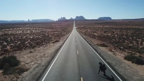Skate Boarding Down Endless Deseert Road Shot on Drone 스톡 동영상 99096260