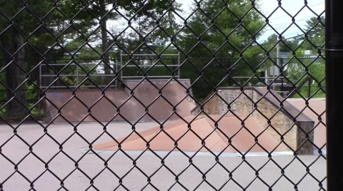 Skateboard park medium shot, through fence, cars in background Video stock 43218488