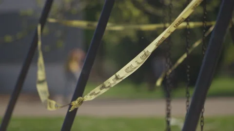 Skateboarder in the background of a playground covered in caution tape Stock-Footage 130390446
