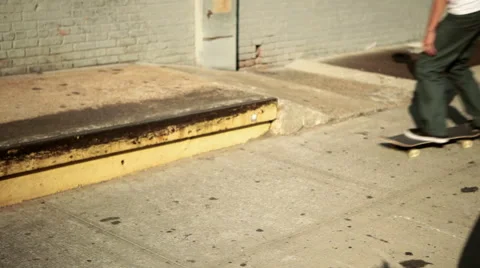 Skateboarder doing trick on sidewalk Stock Footage 60928711