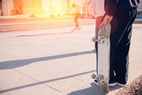 Skateboarder guy is getting ready for trick on skateboard with sunlight Stock Photos
