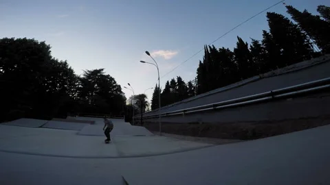 Skateboarder performs tricks in the park in the evening Stock-Footage 94114053