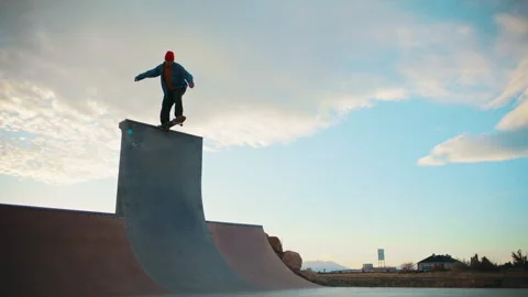 Skateboarder performs tricks at a sunny park ramp during golden hour Stock Footage 310269744