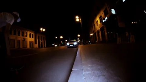 A skateboarder rides and doing a difficult trick on a night street Stock Footage 71819938