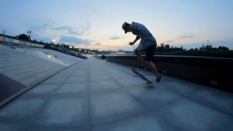 Skateboarder rides and doing tricks on a waterfront in the evening Stock Footage 71781752