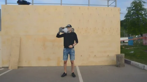 Skateboarder smokes in skate park Stock Footage