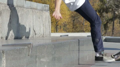 Skateboarder try a grind trick on ledge and falling down on granite Stock Footage 96772564