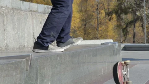 Skateboarder try a grind trick on ledge and skateboard jumps off Stock Footage 96773203