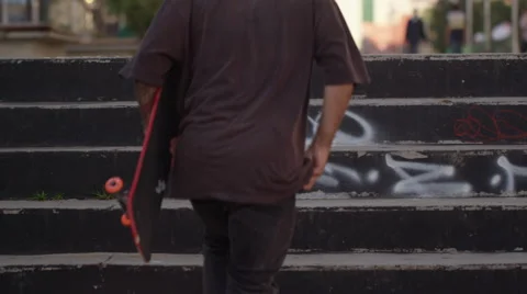 Skateboarder using his mobile phone after climbing the steps Stock Footage 61272973