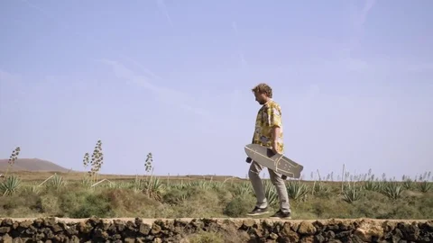 Skateboarder walking in the field Stock Footage 71829366