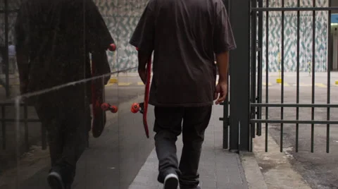 Skateboarder walking on the footpath Stock Footage 61273297