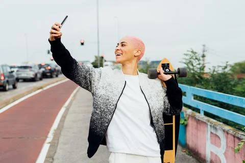 Skateboarder walking, using cellphone Stock Photos