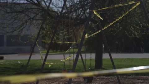 Skateboarders in the background of an empty playground during a pandemic Video stock 130389774