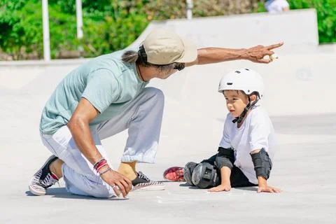 Skateboarding instructor explaining trick to young student in skatepark Stock Photos
