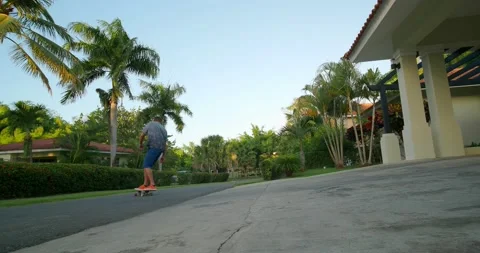 Skater does a surf style carving turn on skateboard on street. Stock Footage 227975965