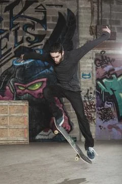 Skater doing impressive backside half cab 180 trick Stock Photos